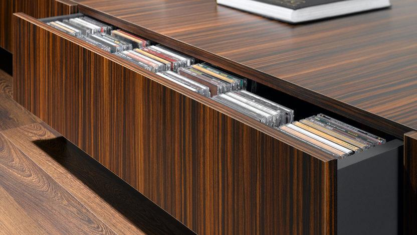 Detailaufnahme eines lackierten Sideboards mit offener Schublade für CD-Aufbewahrung